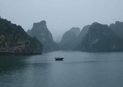 Limestone karst in Ha Long Bay shot through morning fog.