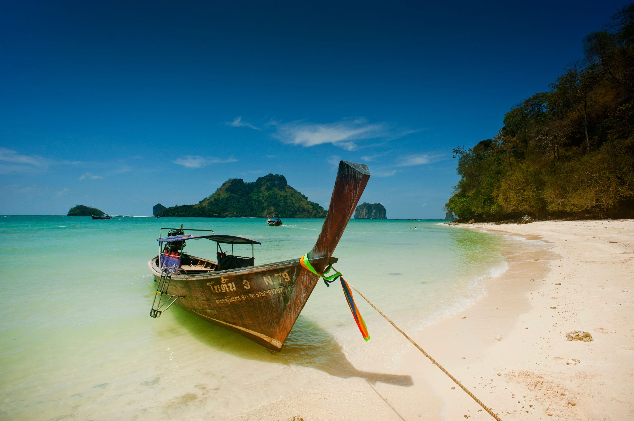 Traditional Longtail Boat on shore near Krabi A traditional longtail boat rests on the shore near Krabi, Thailand